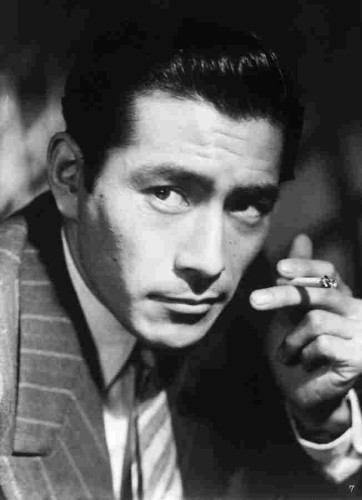 A close up photo of a young Toshiro Mifune, smoking a cigarette and looking effortlessly dashing.