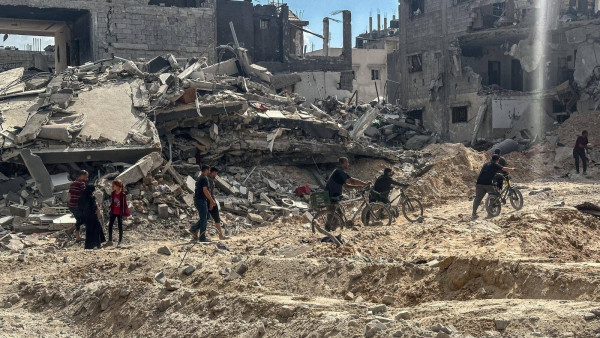 A group of people walking and riding bicycles through rubble and debris in front of partially destroyed buildings.

Original caption:

The Israeli army withdrew from the Jabalia refugee camp, so its residents returned to inspect their homes. (Al-Sharq Al-Awsat)​​​​​​​​​​​​​​​​