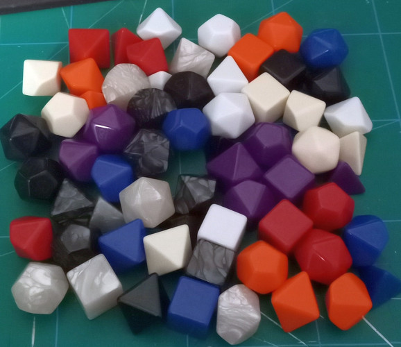 9 sets of polyhedral dice in different colors. At first glance they are completely blank with no numbers.