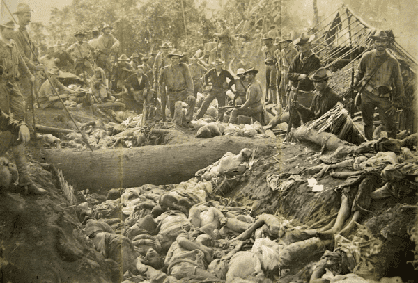 US Soldiers pose with their victims, scattered in a shallow grave, after the massacre. By Pershing, John J. (John Joseph), 1860-1948. - National Archives and Record Administration College Park MD - https://ivc.lib.rochester.edu/wp-content/uploads/2017/02/Fig.-3-Photograph-of-Bud-Dajo-massacre-National-Archives-and-Record-Adminstration-College-Park-MD.jpg, Public Domain, https://commons.wikimedia.org/w/index.php?curid=125374464