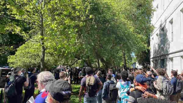 A large number of police and troopers confront protesters at Emory University