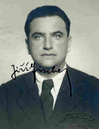 A portrait ID photo of a man in a suit. He has short hair. His hand-written signature is visible in the picture.