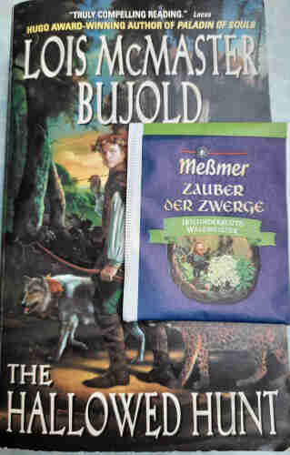 Cover des Buches von Lois McMasters Bujold: The Hallowed Hunt - darauf ein Teebeutel "Zauber der Zwerge" von Messmer.