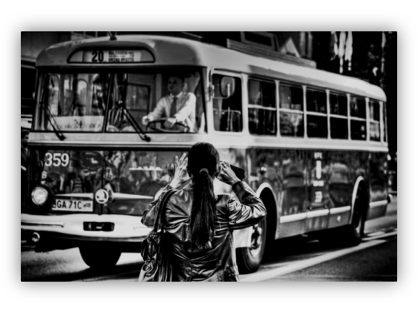 A woman photographs an old trolleybus.
