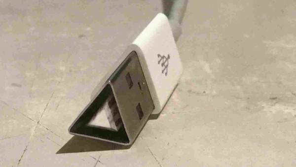 A close-up photo of a USB connector on a desk, except it's triangular. Also, it's a scalene triangle, but only just, and not visibly.