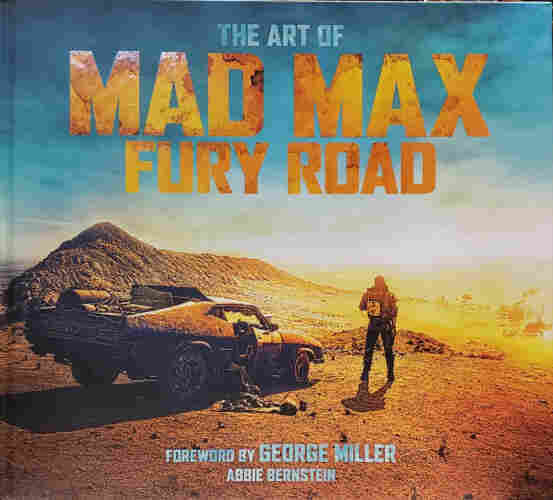 A photo of the front cover of
THE ART OF MAD MAX FURY ROAD.
FOREWORD BY GEORGE MILLER. 
ABBIE BERNSTEIN.
Max, standing near his customized and battered Pursuit Special, faces away, looking downhill into a makeshift city, across barren, arid, and rocky orange desert landscape, beneath a clear blue sky, toward a dust-hazy horizon.