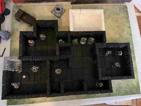 3d printed dungeon with minis scattered in different room 