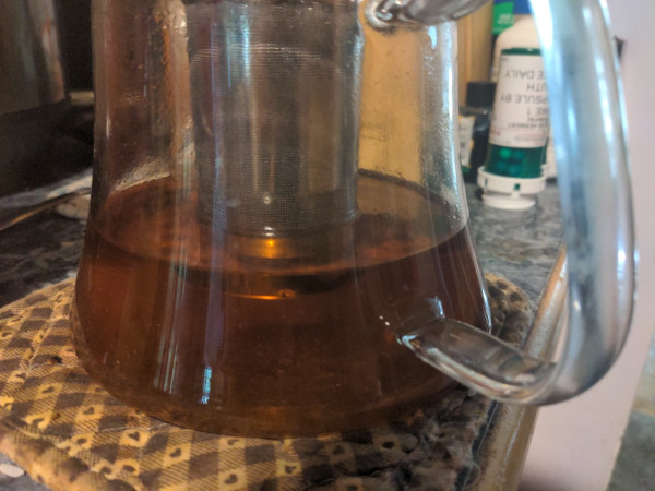 Glass teapot half full with tea.