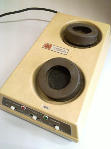 A photo of an Anderson Jacobson acoustic modem, which took a standard phone handset. 

It's basically a low beige box (hey, beige was The Color back in the 80's), with "cord" printed below two large soft rubber, vaguely bagel looking openings you would press the telephone handset into securely so two computers could scream at each other. 