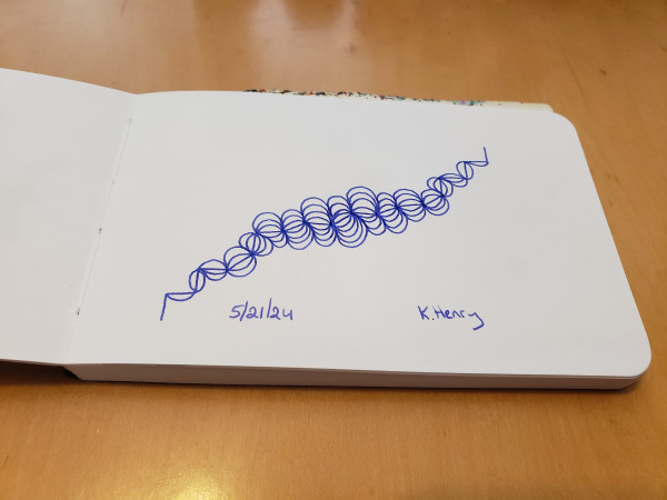 Hand drawn generative/iterative art in ink on an open page of my sketchbook. The pattern looks a bit like a line drawing of a hair scrunchi that's come apart.