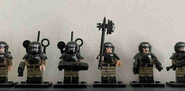 A collection of Warhammer themed LEGO minifigures displayed on a shelf.