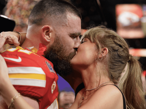Travis Kelce and Taylor kissing on the field after the Super Bowl