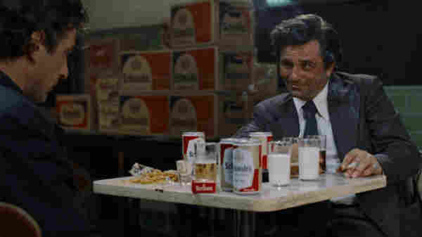 A shot of Peter Falk sitting across from another man at a diner table. The table's covered in beer cans, condiments and glasses of milk