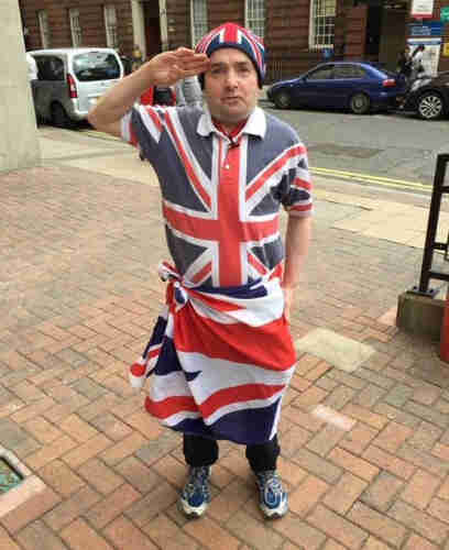 Tiny gammon flagshagging WWII nostalgia monkey giving a salute.  He's dressed head to foot in his beloved flag and giving a salute.  I'm sure he'll be on the first train to the Russian front.