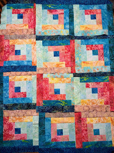 Quilt top showing 12 blocks arranged in a 3x4 matrix. The blocks are multi-colored, with the "bottom" half of each block made with darker toned fabrics and the upper w/light tones.