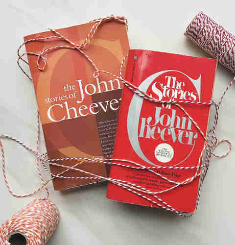 Two different editions of The Stories of John Cheever, wrapped loosely with red, orange, and white butcher string