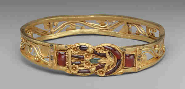 Description from the museum: “The Herakles knot on this sumptuous armband is enriched with floral decoration and inlaid with garnets, emeralds, and enamel. According to the Roman writer Pliny, the decorative device of the Herakles knot could cure wounds, and its popularity in Hellenistic jewelry suggests that it was thought to have the power to avert evil.”