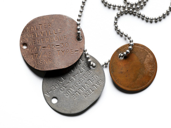 80-year-old dog tags of Walter Melville Weberbaur, strung together with a discolored old coin