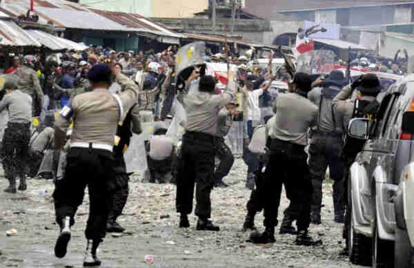 Police attacking protesters in the street during Freeport copper strike.