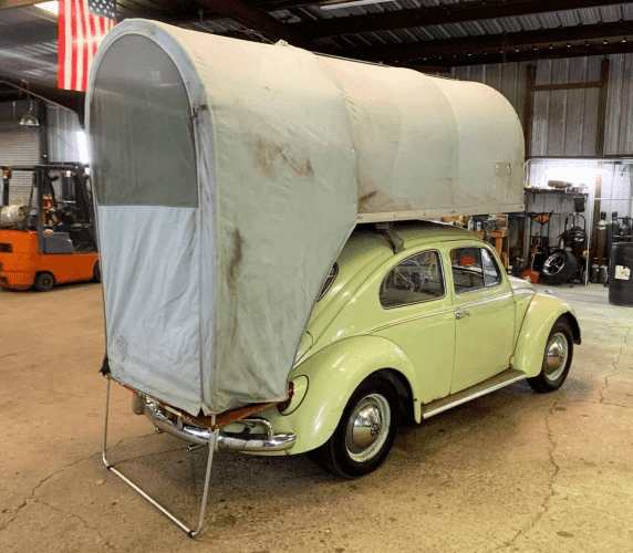 A 1962 Volkswagen Beetle with a period correct Carbak tent.