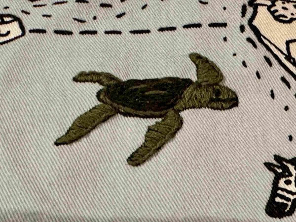  A small green embroidered turtle. 