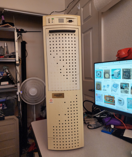 An AT tower sitting on a desk. It's yellowed, with a big plastic door on the front, a MHZ indicator at top, a serial port, and it's got a Pentium Inside logo sticker 