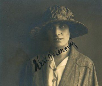Vintage portrait of a person wearing a wide-brimmed hat and a textured jacket. The image features a sepia tone and has cursive handwriting across the bottom.