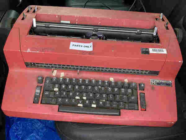 a red IBM Selectric typewriter. it has a Parts Only sticker. 