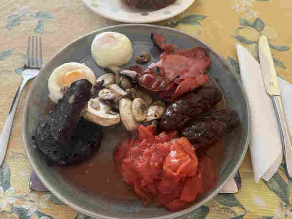 Home made English breakfast: poached eggs, black pudding, mushrooms, plum tomatoes, bacon, and sausages. 