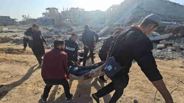 journalists carrying an injured palestinian during their coverage of Israeli assault on Gaza.
