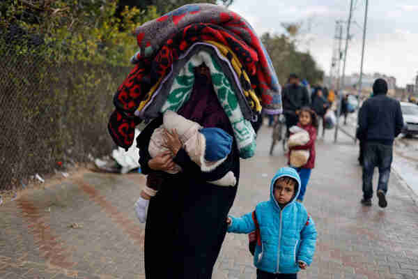 A woman holds a baby as Palestinians fleeing Khan Younis, due to the Israeli ground operation, move towards Rafah in the southern Gaza Strip, January 29. REUTERS/Mohammed Salem