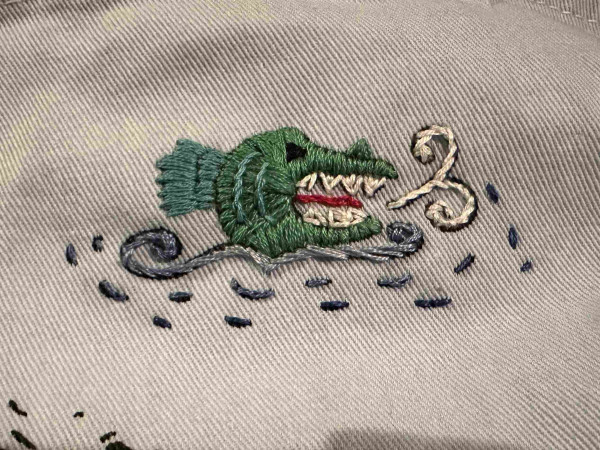 A small Green embroidered sea monster head 