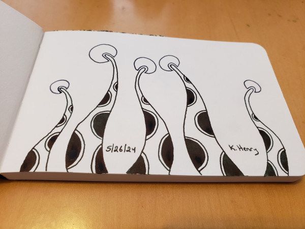 Hand drawn generative art in ink on an open page of my sketchbook. The abstract pattern looks a bit like looking up polka-dotted dandelion stems.
