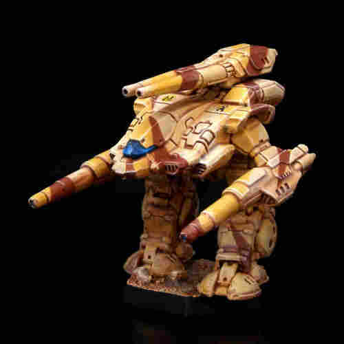 A painted miniature of a Stone Rhino 'Mech.  It is painted in tan and brown desert camo.  The black scorpion emblem of Clan Goliath Scorpion is on the left torso.