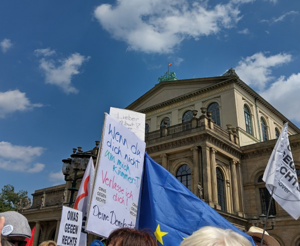 Demoplakate am 8. Juni vor dem Pride-beflaggten Opernhaus Hannover

"Wenn du dich nicht um mich kümmerst, verlasse ich dich!
Deine Demokratie" zwischen Omas gegen Rechts
