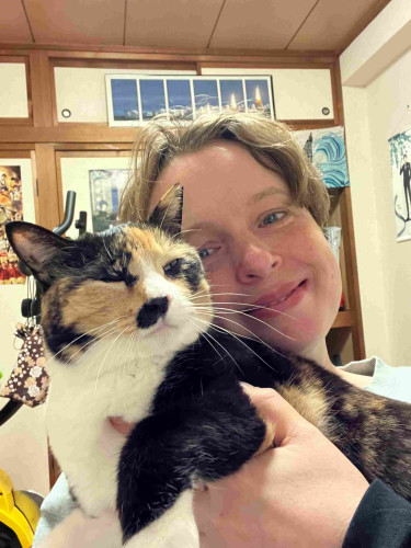 Selfie of me holding a calico cat. We both look happy. 
