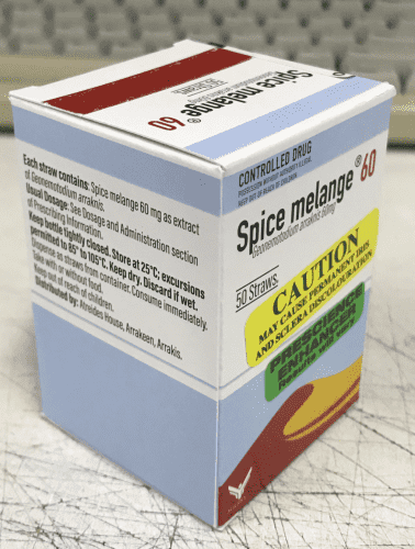A photo of a medication box for Spice melange 60 straws. The box has a blue sky and sand dune image, with warnings. CAUTION MAY CAUSE PERMANENT IRIS AND SCLERA DISCOLOURATION and PRESCIENCE ENHANCER RESULTS WILL VARY. 