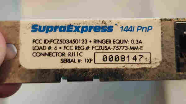 A label on a rusty/grimy ISA card.
It reads: SupraExpress 144i PnP
FCC ID: FCZ5D3450123 Ringer Equiv: 0.3a
Load #: 6
FCC REG #: FCZUSA-75773-MM-E
Connector: RJ11C
Serial # 1XP 0008147