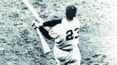 A black-and-white photo showing the back of baseball hitter Bobby Thomson with his number 23 after the follow-through of his swing known as “The Shot Heard Round the World”, which  won the Pennant for the 1961 New York Giants.