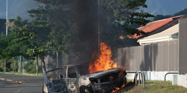 a car is burning after riots against France change of rules in New Caledonia
