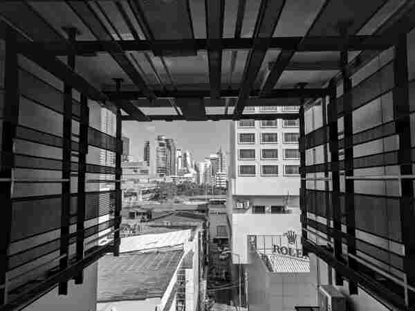 Black and white view of city through construction beams of mid rise building captured with Google Pixel in Bangkok Thailand