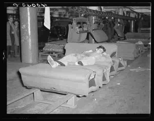 Young striker off sentry duty sleeping on assembly line of auto seats. By Sheldon Dick - This image is available from the United States Library of Congress&#039;s Prints and Photographs divisionunder the digital ID fsa.8c28672.This tag does not indicate the copyright status of the attached work. A normal copyright tag is still required. See Commons:Licensing for more information., Public Domain, https://commons.wikimedia.org/w/index.php?curid=2283947
