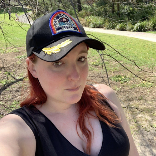 Elissa, a red haired very pale girl, wearing a replica of the Nostromo crew cap that Harry Dean Stanton wears in Alien (1979).

It’s my lucky cap. Nothing bad happens when you’re crewing the Nostromo!