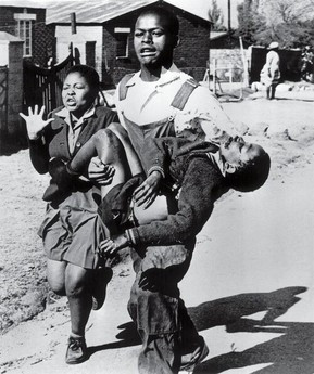 Hector Pieterson being carried by Mbuyisa Makhubo after being shot by the South African police. His sister, Antoinette Sithole, runs beside them. Pieterson was rushed to a local clinic where he was declared dead on arrival. This photo by Sam Nzima became an icon of the Soweto uprising. By Sam Nzima - Dzambukira, Proud (November 5, 2006). "Remember, Remember the Fifth of November". Harvard Computer Society., Fair use, https://en.wikipedia.org/w/index.php?curid=27740971