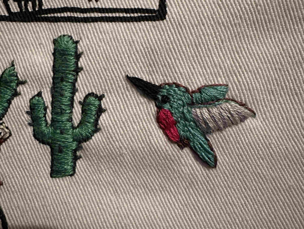 A small embroidered green and pink hummingbird 
