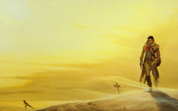 A determined Roland Deschain trudges across a barren desert landscape painted in yellows. He wears a leather duster with red kerchief around his neck. A pack is slung over his shoulder and his gun belts are crossed at his waist. Sand blows across his path as he walks toward a half buried skull.