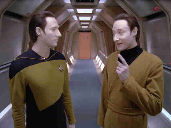 Lore lecturing Data (both played by Brent Spiner) in a hallway of the Enterprise-D. While it may appear that Lore is merely waggling his finger, his thumb is also standing away from the rest of his hand. Is he measuring something?