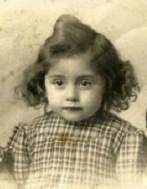 Vintage black and white portrait of a young girl with curly hair, wearing a checkered dress.