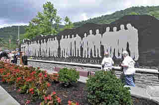 Photo of Upper Big Branch Mine disaster Memorial by Steven Rotsch, with silhouettes of the victims on black marble wall. By Original work: designed by Rob Dinsmore of the Chapman Technical Group and built by Pray ConstructionDepiction: Steven Rotsch - small 320 size of https://www.flickr.com/photos/governortomblin/7659008962/, Fair use, https://en.wikipedia.org/w/index.php?curid=70502796