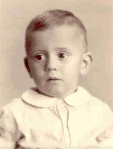 An ID photo of a little boyu dressed in white shirt. He has short blonde hair.